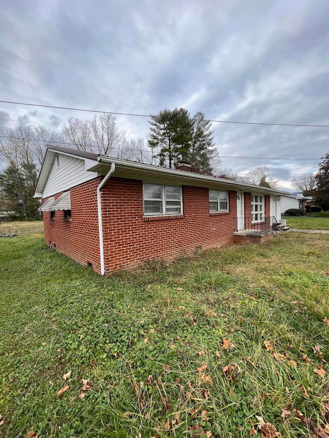 view of side of home with a lawn