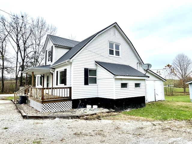 rear view of property featuring covered porch