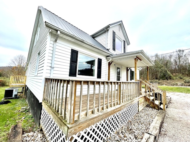 view of property exterior with covered porch and central air condition unit