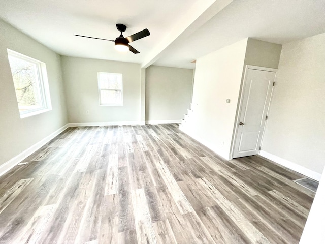 empty room with ceiling fan and light hardwood / wood-style flooring