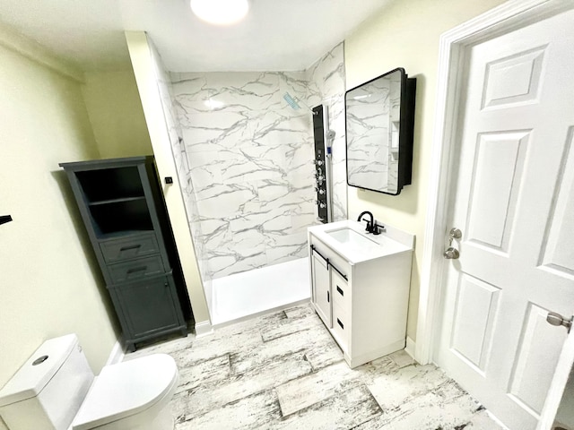 bathroom with a tile shower, vanity, and toilet