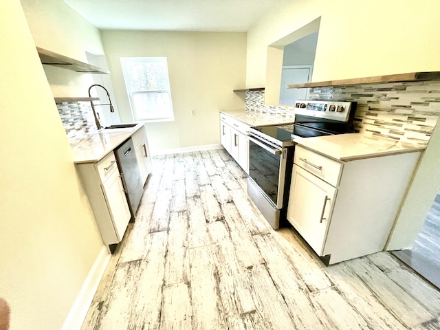 kitchen featuring white cabinets, light wood-type flooring, backsplash, and appliances with stainless steel finishes