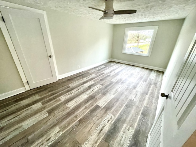 unfurnished bedroom featuring hardwood / wood-style flooring, ceiling fan, and a textured ceiling