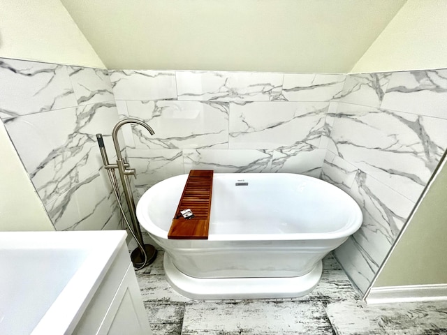 bathroom with a tub to relax in and tile walls