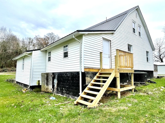 back of property with a yard and central AC unit