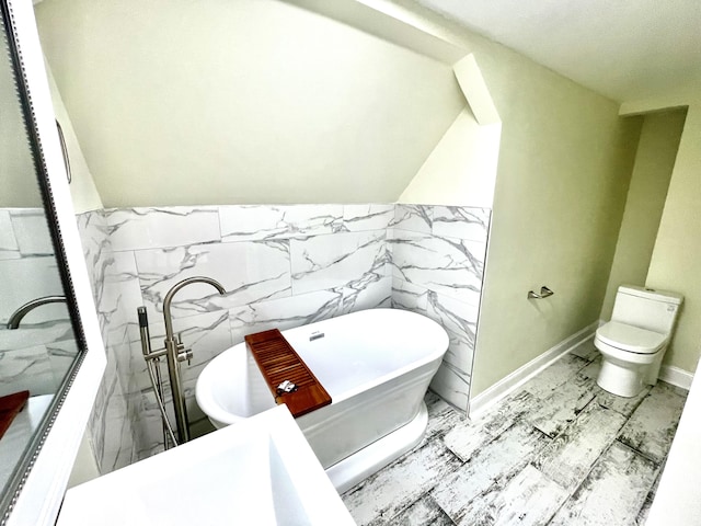 bathroom with a washtub, toilet, and tile walls