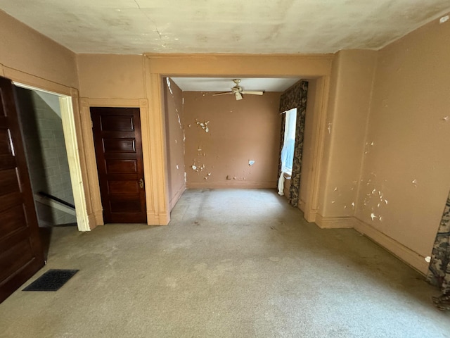 empty room featuring ceiling fan and light colored carpet