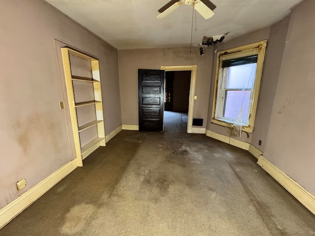 spare room featuring baseboard heating, dark carpet, and ceiling fan