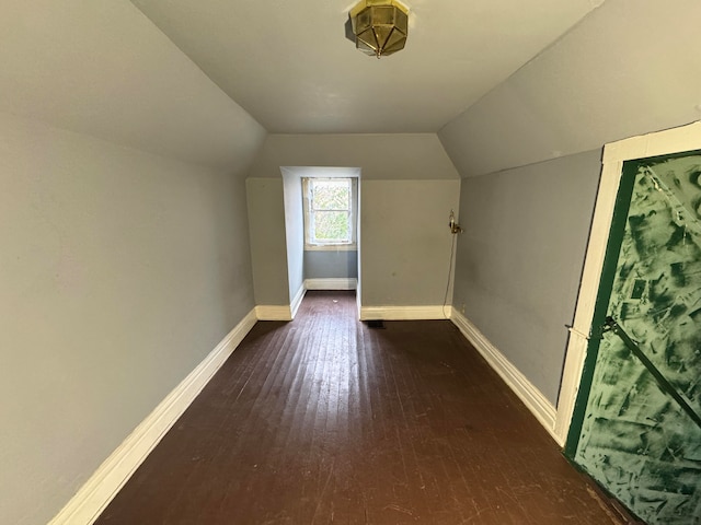 additional living space with dark hardwood / wood-style floors and vaulted ceiling