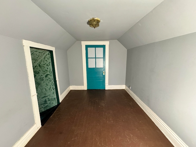 additional living space with hardwood / wood-style floors and vaulted ceiling