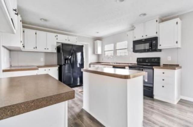 kitchen featuring black appliances, a kitchen island, white cabinets, and wood-type flooring