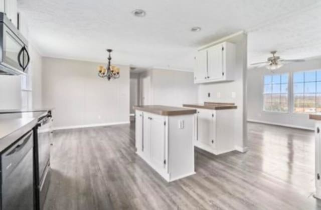 kitchen featuring white cabinets, dark hardwood / wood-style floors, a center island, and appliances with stainless steel finishes