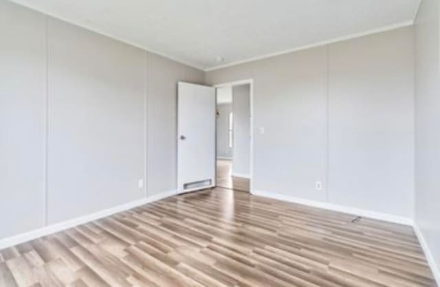 unfurnished room with light hardwood / wood-style floors and ornamental molding