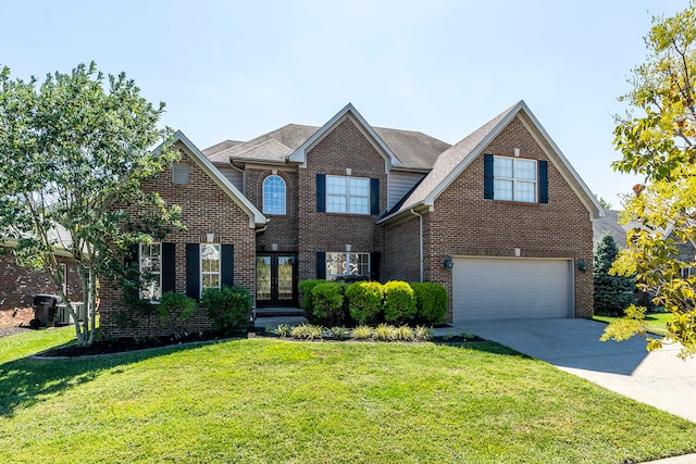 front facade featuring a garage, a front yard, and french doors