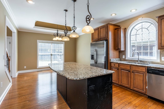 kitchen with a kitchen island, light hardwood / wood-style floors, sink, and appliances with stainless steel finishes