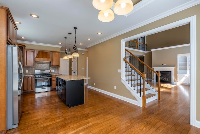 kitchen featuring dark hardwood / wood-style flooring, light stone counters, custom range hood, stainless steel appliances, and a center island