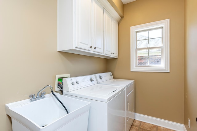 clothes washing area featuring cabinets, washing machine and dryer, and sink