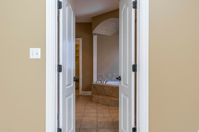 bathroom with tile patterned floors and tiled bath