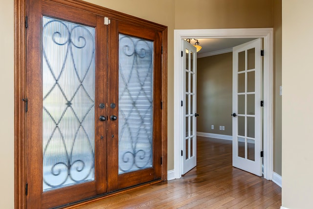 entryway featuring crown molding, light hardwood / wood-style flooring, and french doors