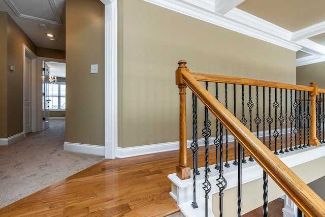 stairs featuring hardwood / wood-style floors, beam ceiling, ornamental molding, and coffered ceiling