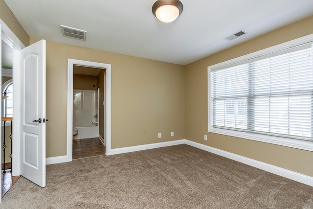 unfurnished bedroom with ensuite bath and light carpet