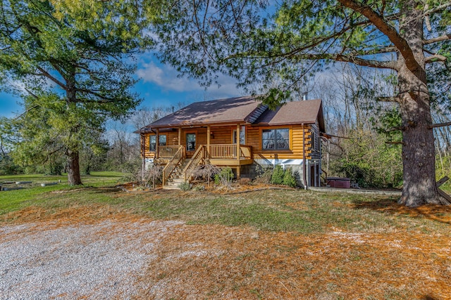 log-style house featuring a front lawn and covered porch