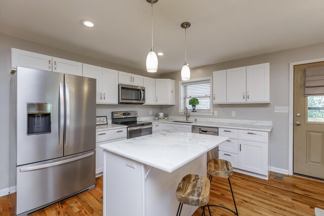 kitchen with light stone counters, sink, white cabinetry, and appliances with stainless steel finishes