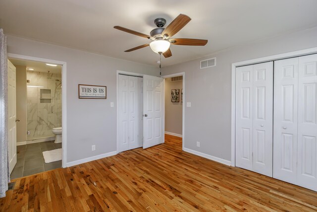 spare room featuring hardwood / wood-style flooring, ceiling fan, and wood walls