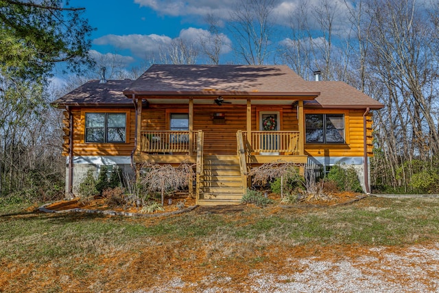 cabin with a front lawn and a porch