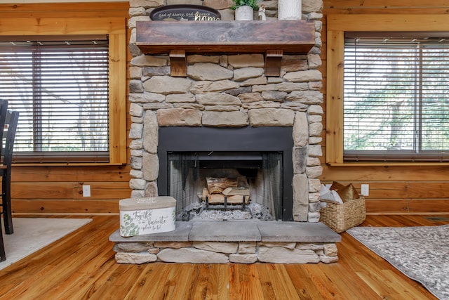 interior details featuring hardwood / wood-style floors, wood walls, and a fireplace