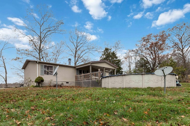 exterior space with crawl space, a covered pool, and a front lawn