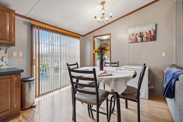 dining space with vaulted ceiling, light wood finished floors, crown molding, and a notable chandelier