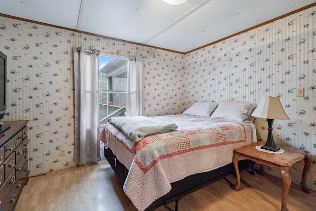 bedroom with wallpapered walls, ornamental molding, and wood finished floors