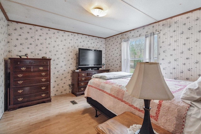 bedroom with ornamental molding, light wood-style flooring, and wallpapered walls