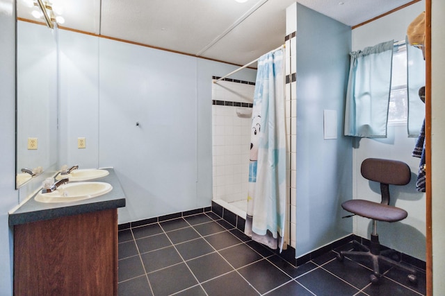 bathroom featuring tile patterned flooring, a sink, a shower stall, and double vanity