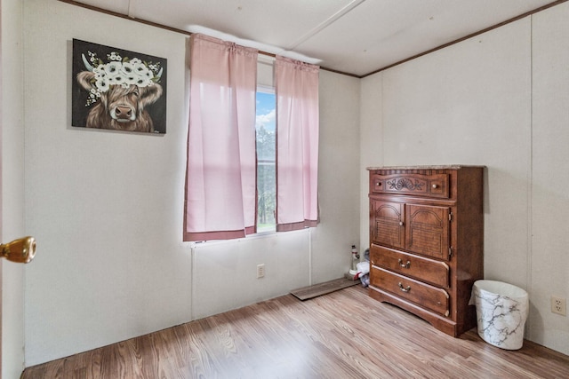 bedroom featuring crown molding and light wood-type flooring