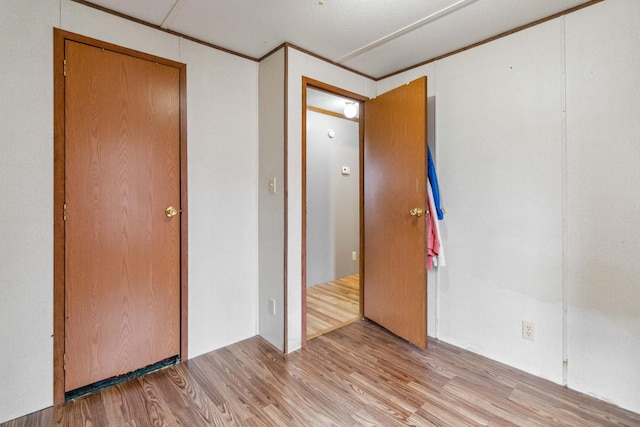 empty room with ornamental molding and light wood finished floors