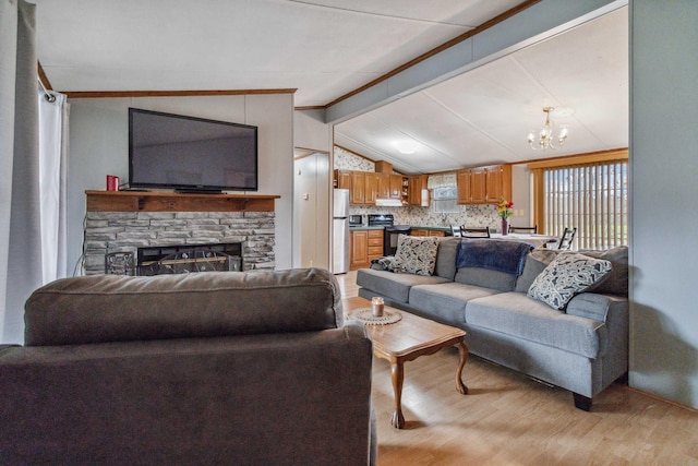 living room with a stone fireplace, vaulted ceiling with beams, a chandelier, and light hardwood / wood-style flooring