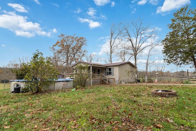 back of house featuring crawl space, a covered pool, an outdoor fire pit, and stairs