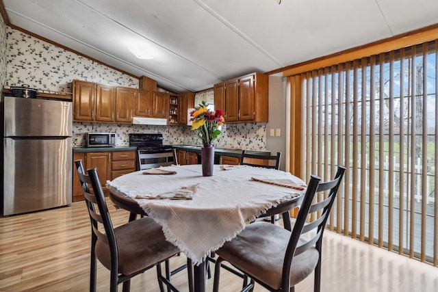 dining space with lofted ceiling and light wood-type flooring