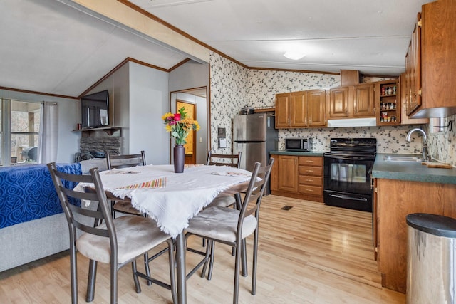 kitchen featuring under cabinet range hood, stainless steel appliances, vaulted ceiling, open shelves, and dark countertops