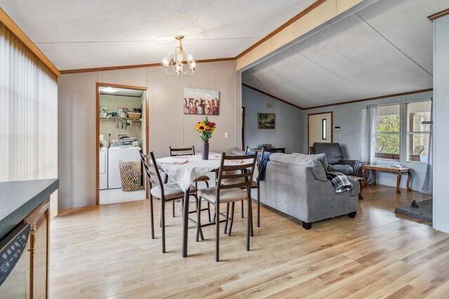 dining room featuring crown molding, light wood finished floors, washing machine and clothes dryer, lofted ceiling, and a chandelier