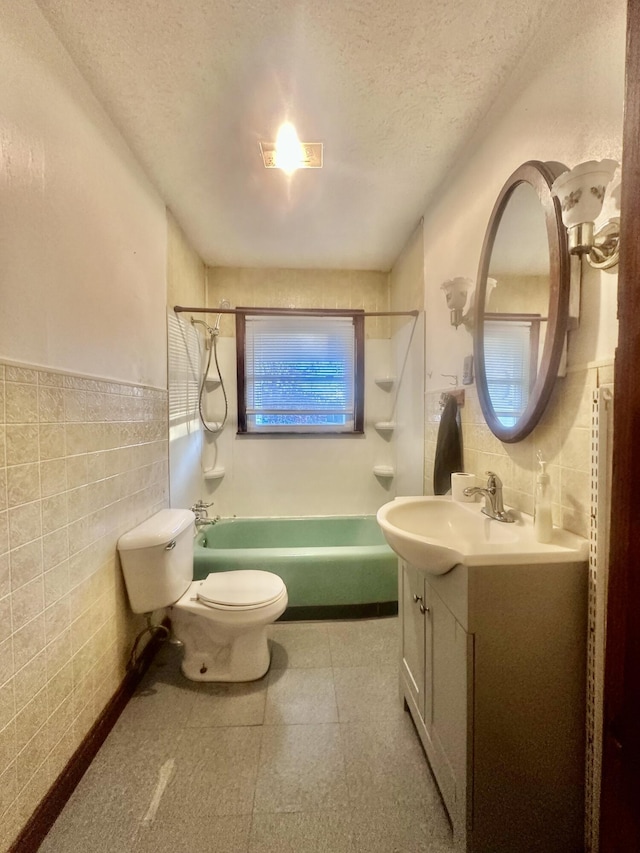 full bathroom featuring a textured ceiling, shower / bathing tub combination, and tile walls