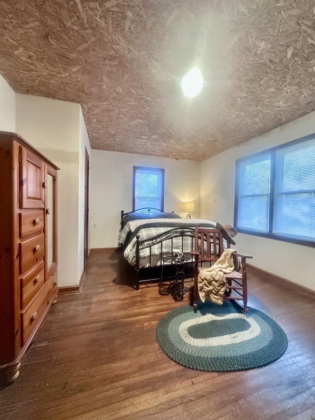 bedroom with hardwood / wood-style floors and a textured ceiling