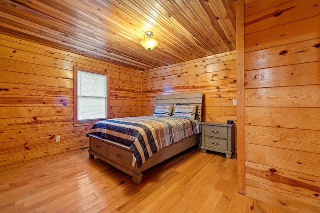 bedroom with light hardwood / wood-style flooring, wood ceiling, and wood walls