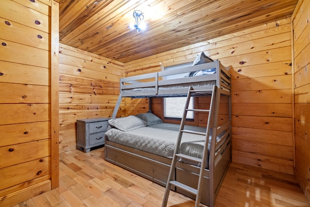 bedroom with wood walls and light hardwood / wood-style flooring