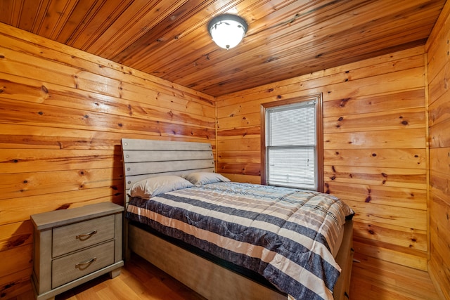 bedroom featuring wooden walls, light hardwood / wood-style flooring, and wood ceiling