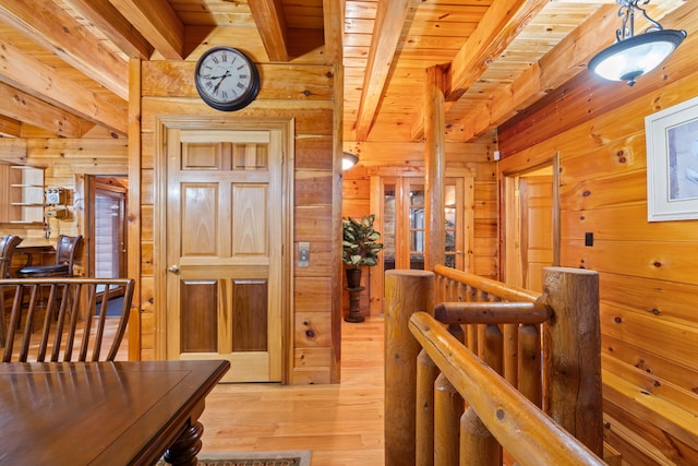 corridor featuring beam ceiling, light hardwood / wood-style flooring, wooden walls, and wood ceiling