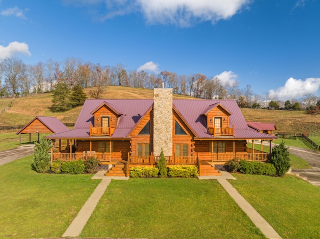 log home featuring covered porch and a front yard