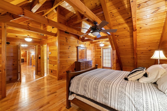 bedroom with vaulted ceiling with beams, wooden ceiling, light hardwood / wood-style floors, and wood walls